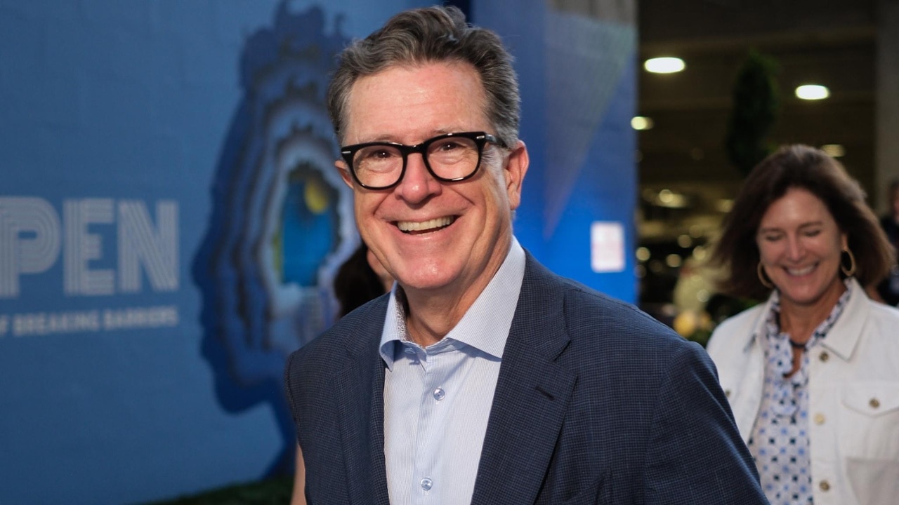 Stephen Colbert makes a splash on the blue carpet during tournament festivities